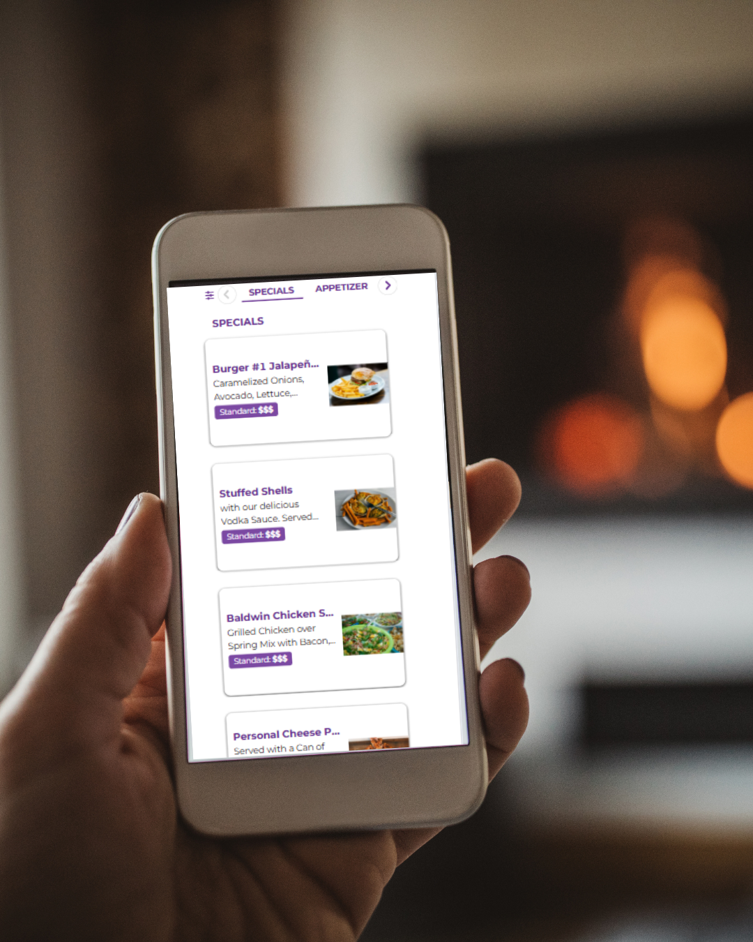 A hand holds a phone displaying the DealMagik app's "Specials" menu, showing various food items.